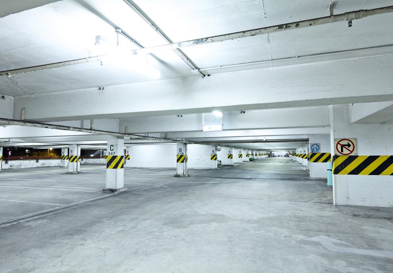 Gray coated parking deck with bright yellow safety striping and painted lane markings